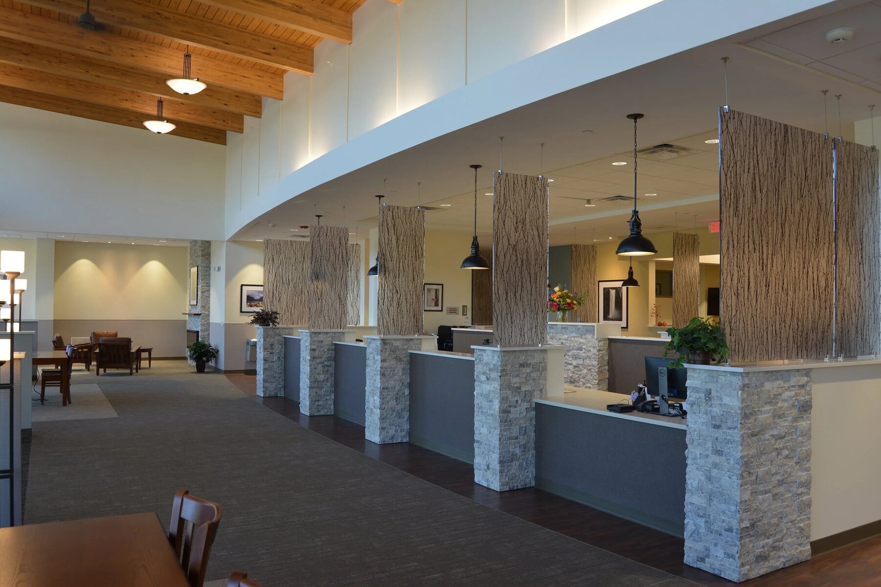 The reception area at our Syracuse office, with a curved soffit, cedar ceiling, and stone-clad check-in counters
